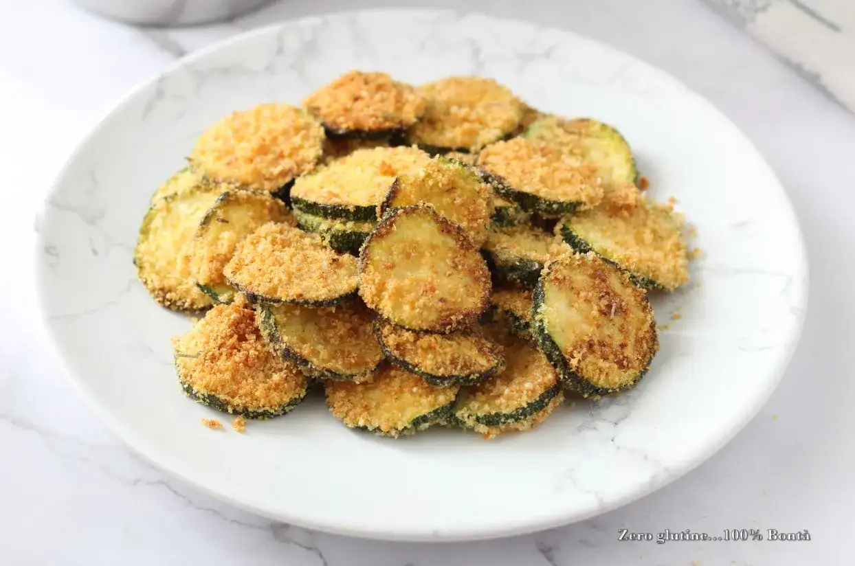 Fette di zucchine croccanti e dorate, cotte in friggitrice ad aria. Un contorno sano e gustoso, perfetto per ogni pasto.
