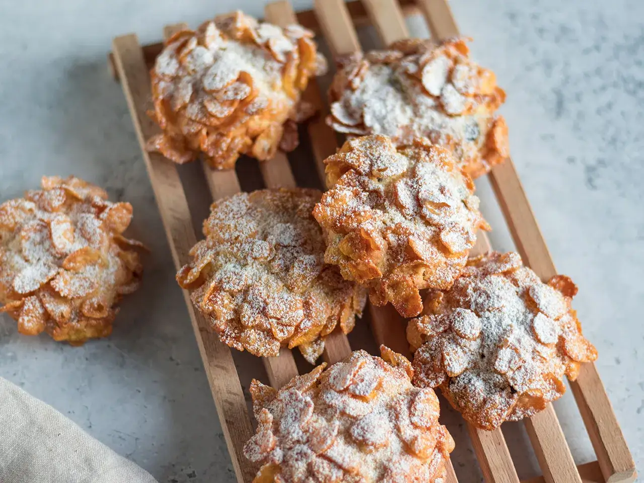 Dolci croccanti, simili a rose del deserto, ricoperti di fiocchi di mais e spolverati di zucchero a velo.