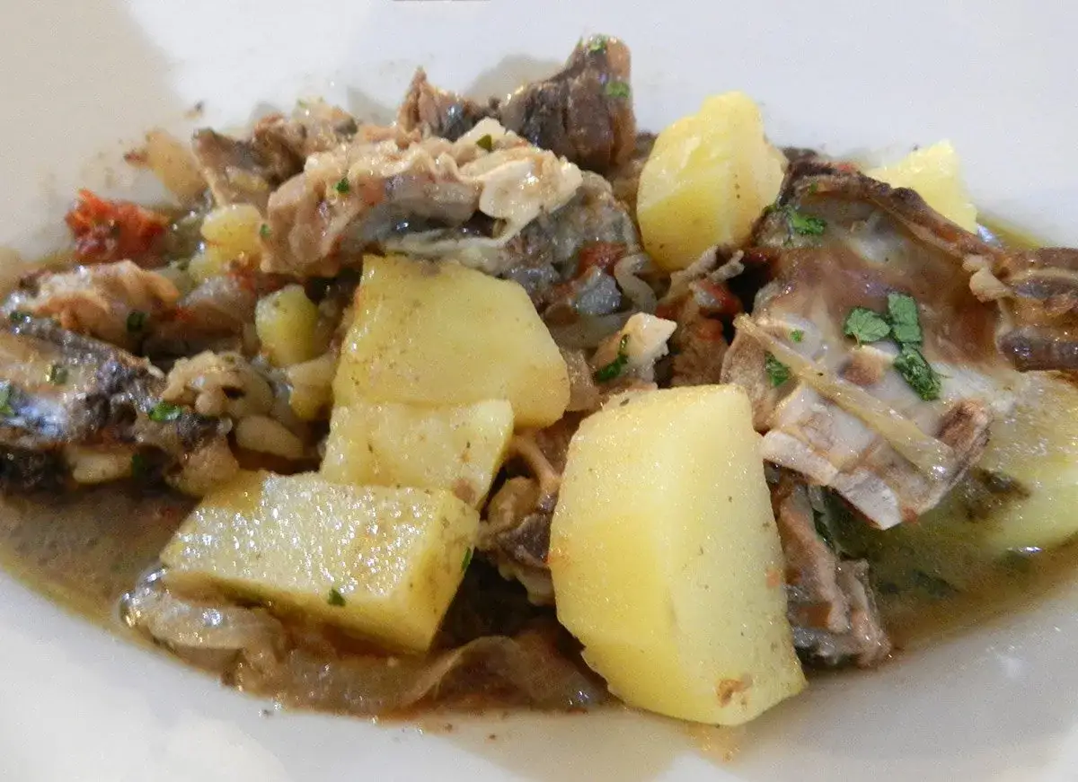 Un saporito capretto in umido con patate, un piatto tradizionale ricco di gusto e profumi.