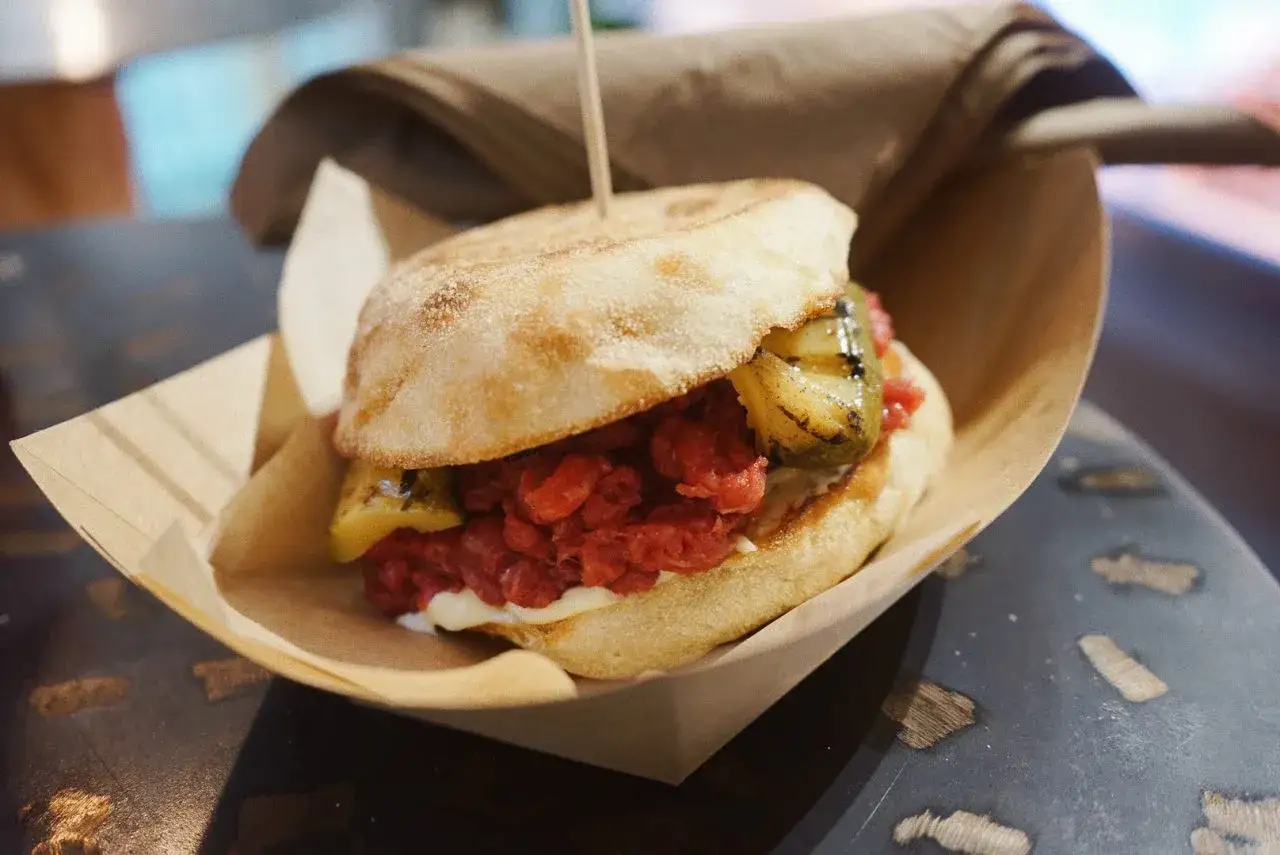 Hamburger con tartare di manzo, peperoni grigliati e pane rustico. Una delizia che non è carne di cavallo vietata.