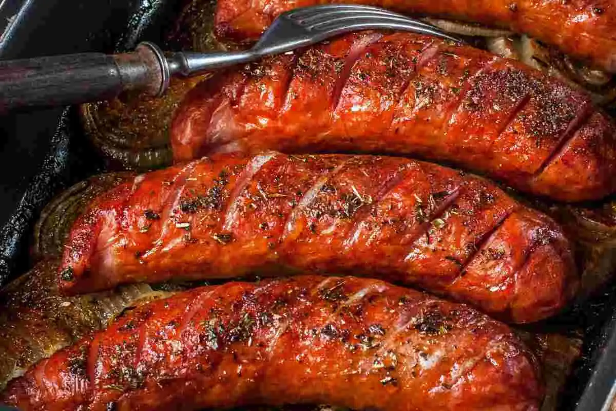 Salsiccia succulenta e dorata, appena sfornata dalla friggitrice ad aria, con erbe aromatiche e un tocco di forchetta.