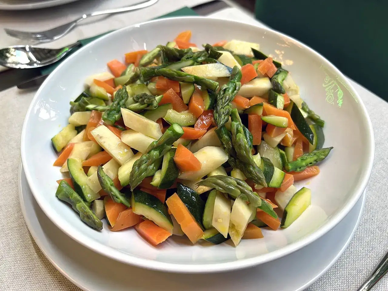 Un piatto invitante di verdure in padella: carote, zucchine e asparagi tagliati a pezzetti, cotti al punto giusto per un contorno sano e colorato.