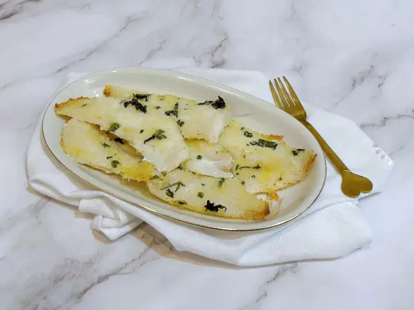 Delizioso merluzzo in friggitrice ad aria, croccante fuori e morbido dentro, guarnito con erbe aromatiche.