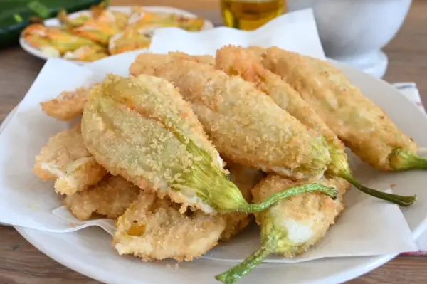 Fiori di zucca fritti, croccanti e dorati, preparati con una leggera pastella per fiori di zucca.