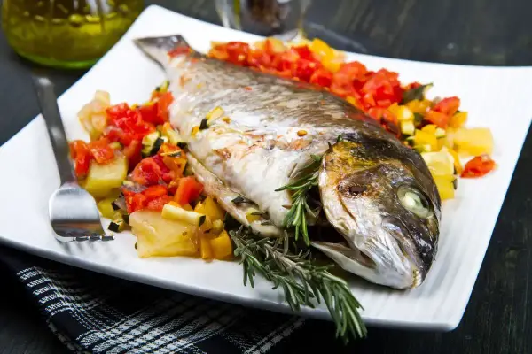 Orata intera cotta in friggitrice ad aria, servita con verdure miste e rosmarino.