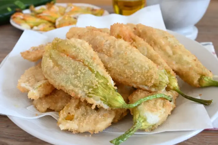 Fiori di zucca fritti, croccanti e dorati, preparati con una leggera pastella per fiori di zucca.